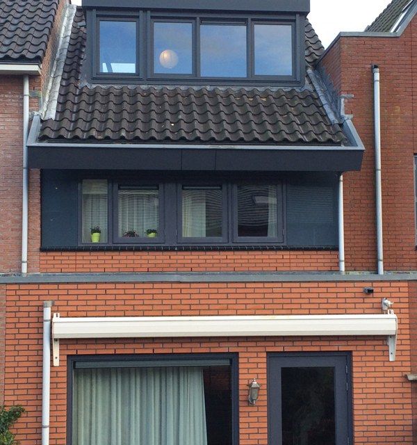 Foto dakkapel zwart bij oranje huis