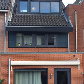 Foto dakkapel zwart bij oranje huis